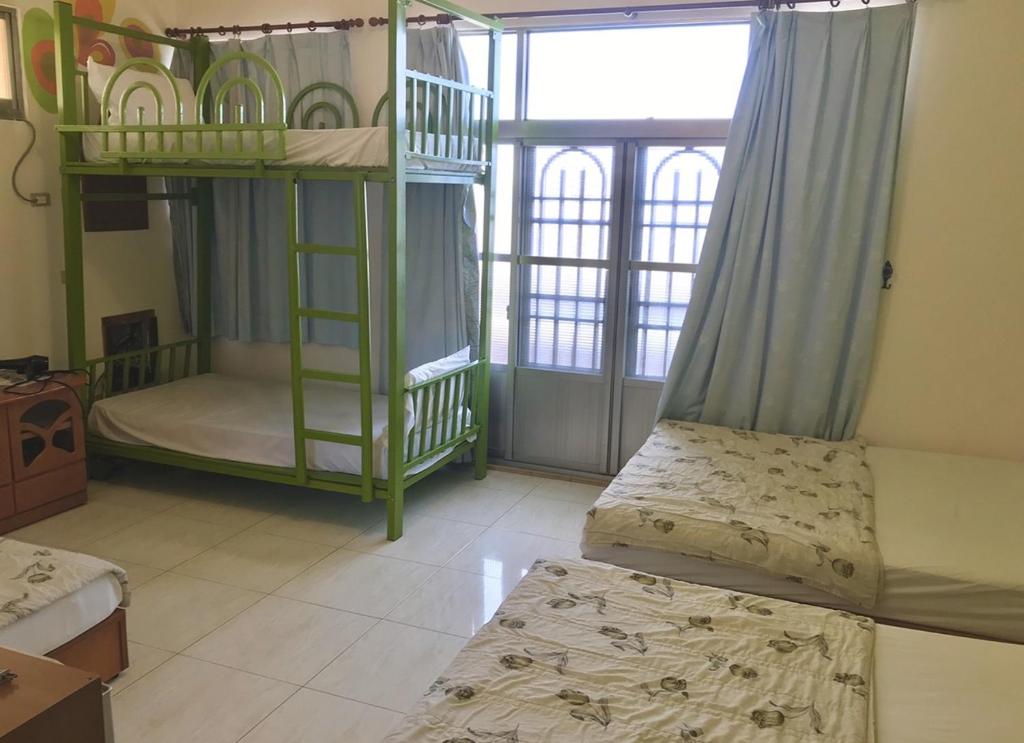 a bedroom with two bunk beds and a window at Fu Yuan B&amp;B in Magong