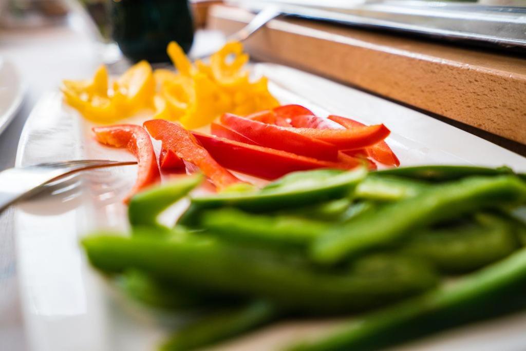 a plate with peppers and vegetables on a table at Pensiunea Junior in Cluj-Napoca