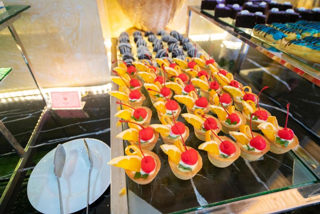 A glass display case filled with small fruit-topped pastries.