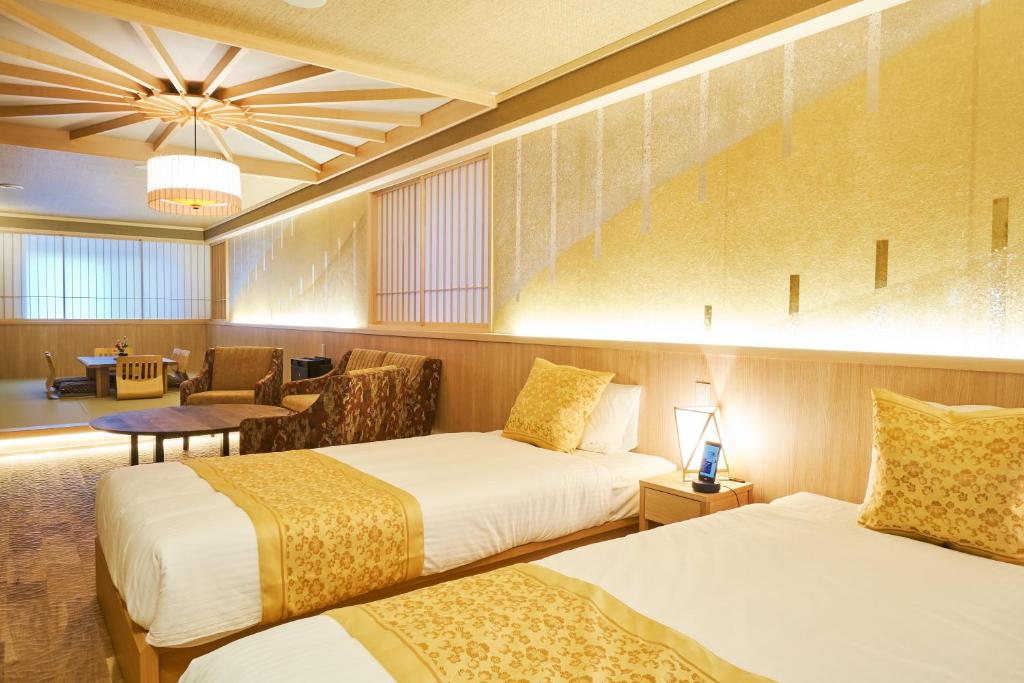 a hotel room with two beds and a chair at SHIKI Seasonal Colors Kanazawa in Kanazawa