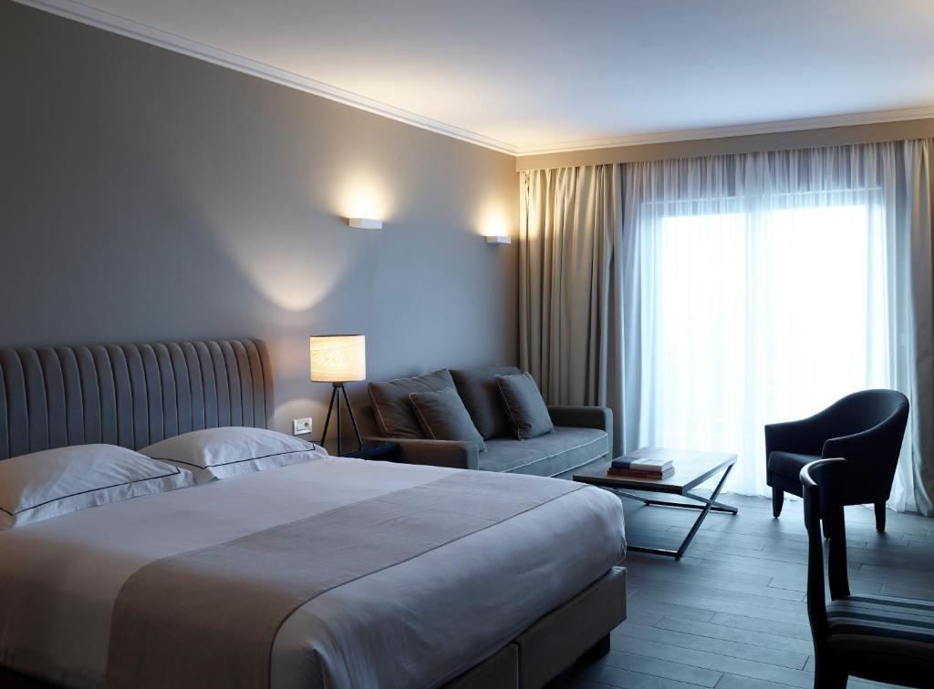 A bed or beds in a room at Pelagos Suites Hotel & Spa