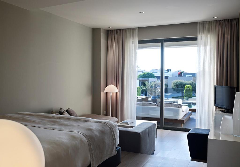 A bed or beds in a room at Pelagos Suites Hotel & Spa