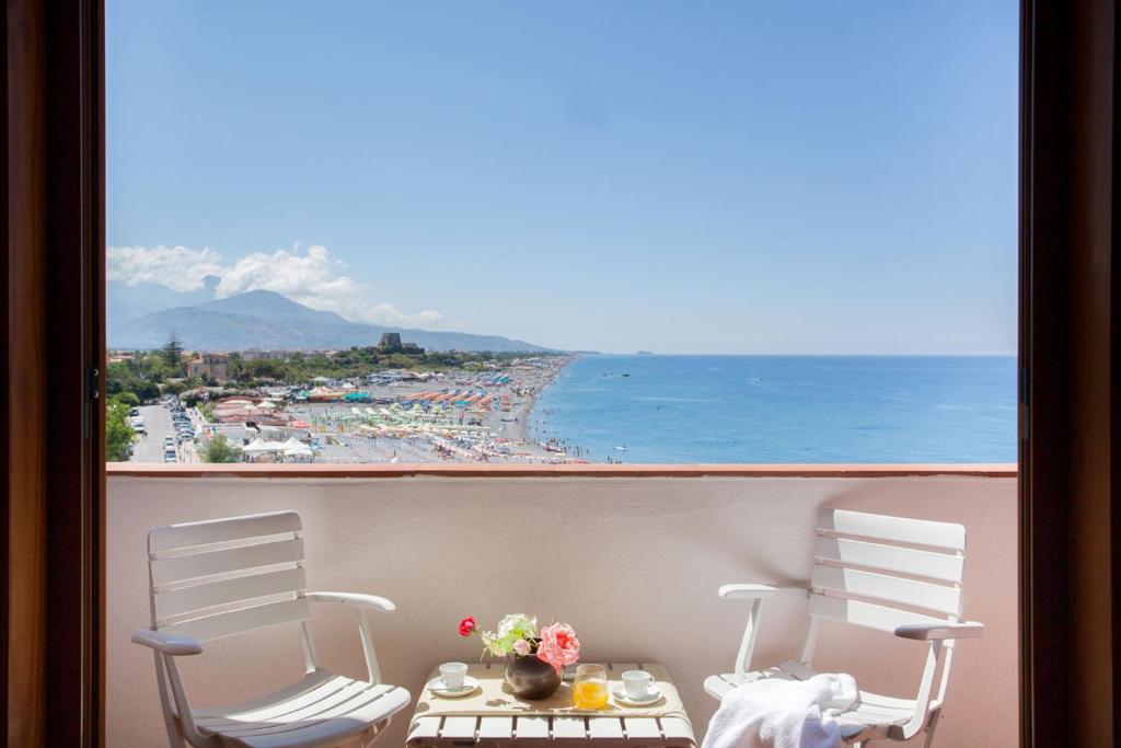 a view of a beach from a balcony with two chairs at Grand Hotel De Rose in Scalea
