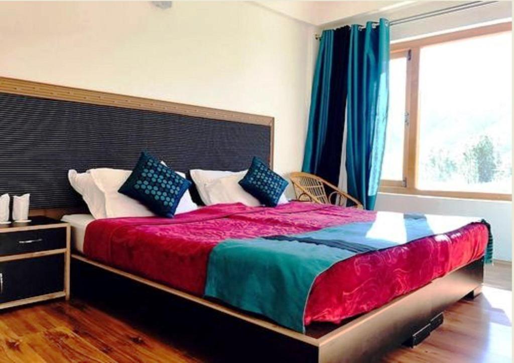 a bedroom with a large bed with a large window at Himalayan Residency Ladakh in Leh