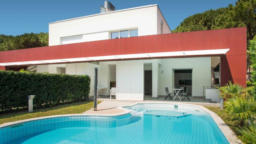 a house with a swimming pool in front of it at Villa Riva Beachfront in Lignano Sabbiadoro