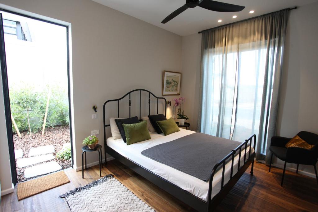 a bedroom with a bed and a large window at Zohara boutiqe suite in Caesarea