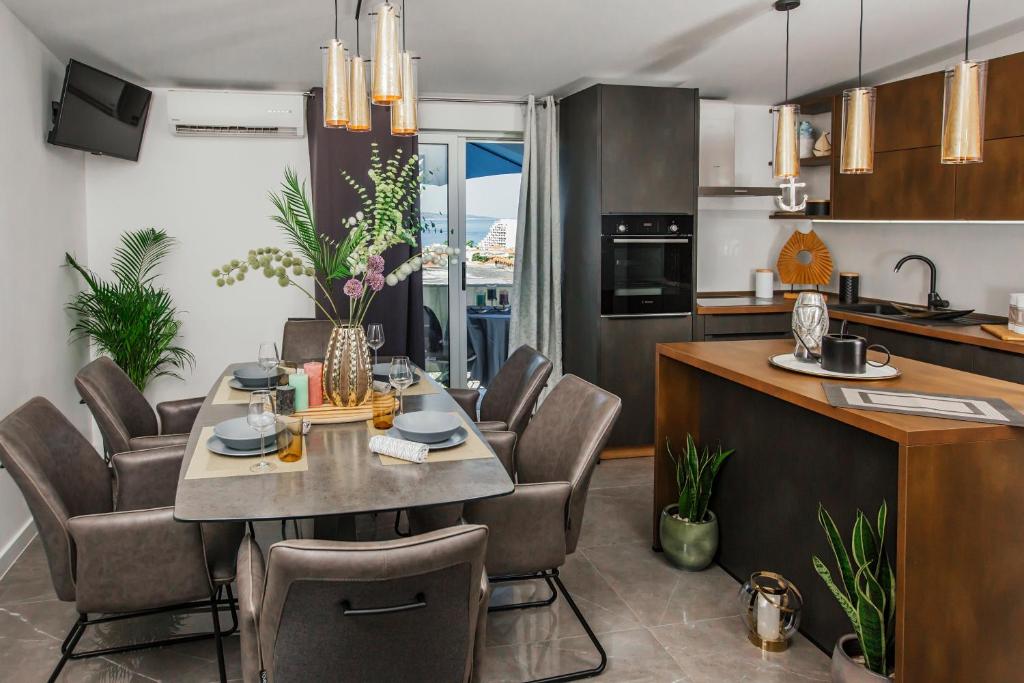 een keuken en eetkamer met een tafel en stoelen bij Apartments Nora in Makarska