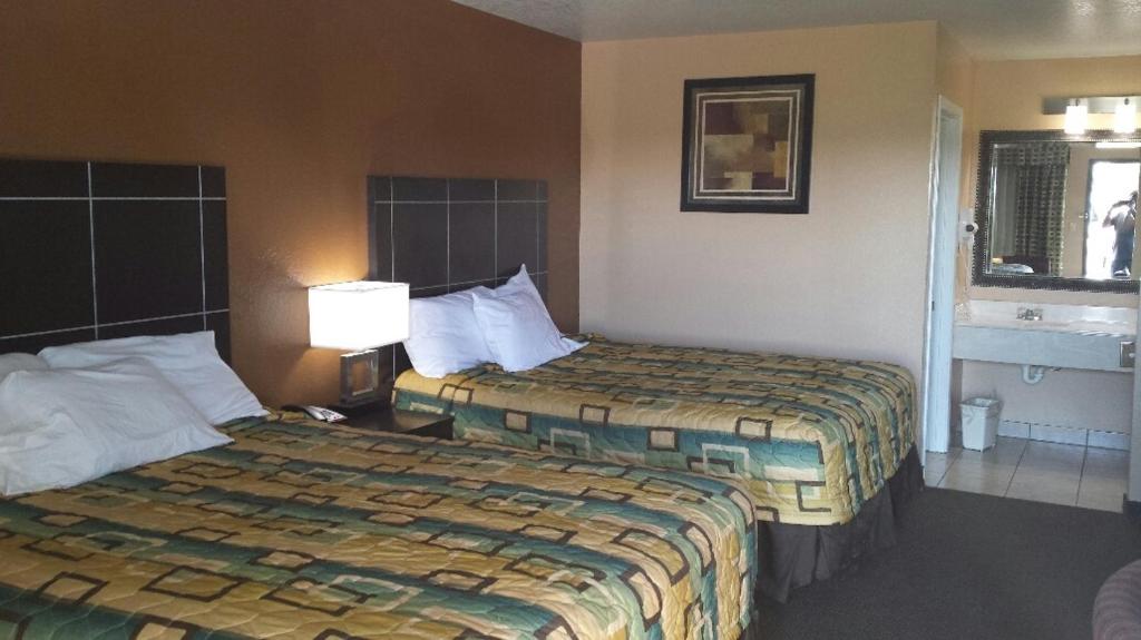 a hotel room with two beds and a window at Sona Inn in Dilley