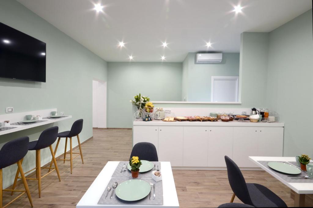 une cuisine et une salle à manger avec tables et chaises dans l'établissement Napoliseason Rooms & Breakfast, à Naples