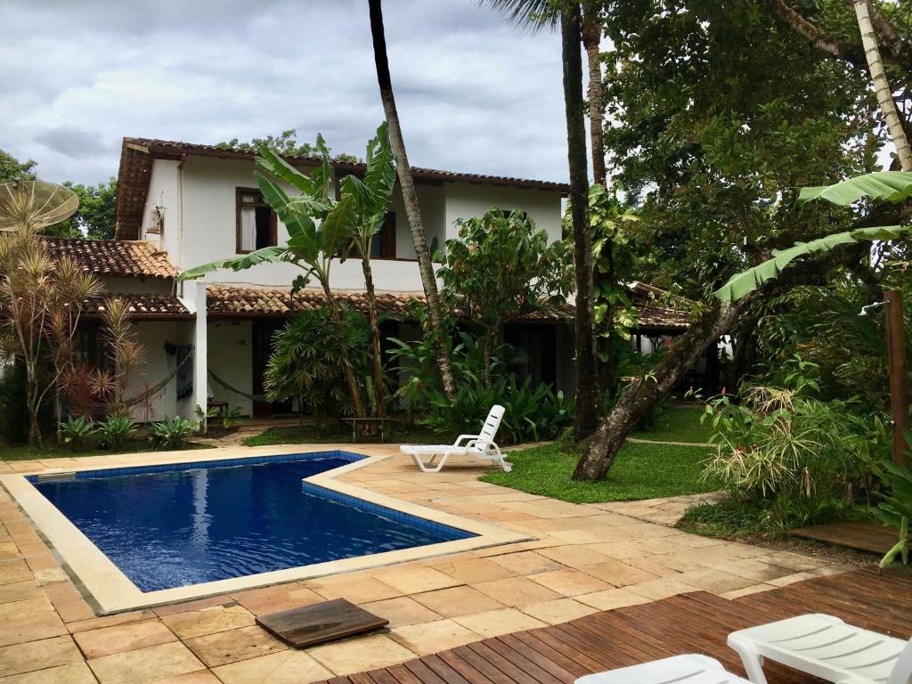 uma villa com piscina em frente a uma casa em Pousada Coqueiro Verde em Itacaré