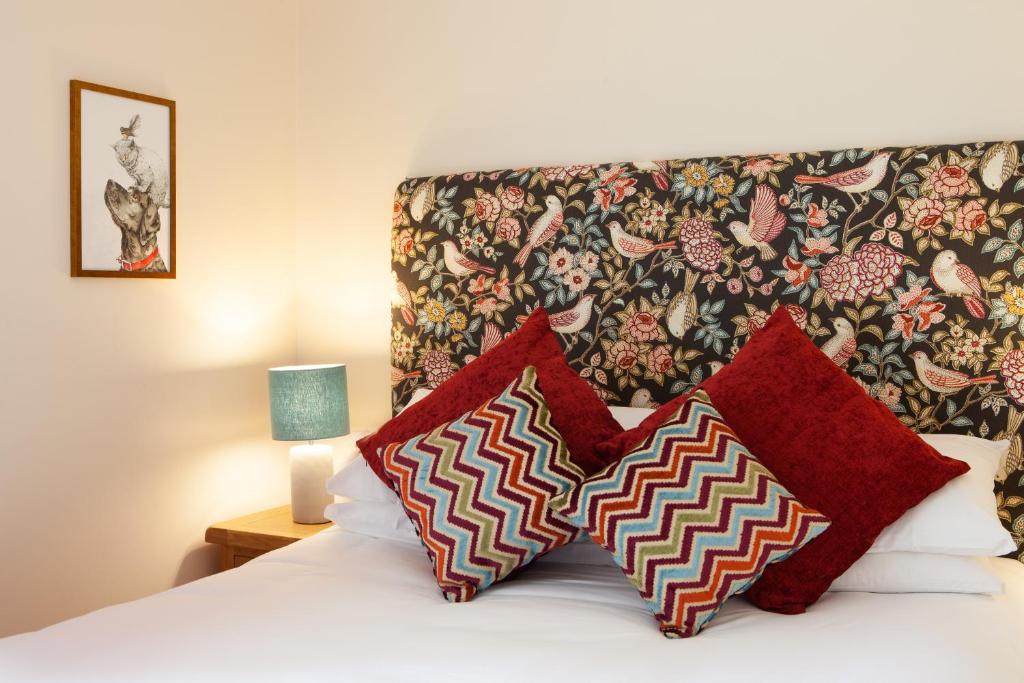 - une chambre avec un lit et 2 oreillers rouges dans l'établissement Banbury Hill Farm, à Charlbury