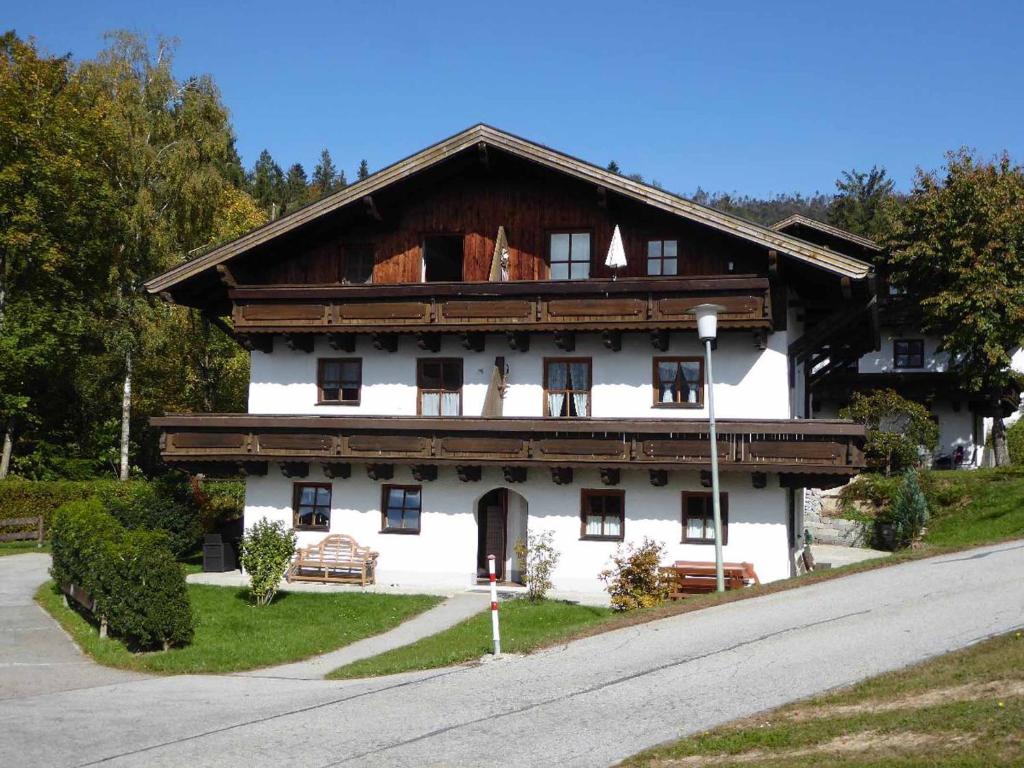 a large white house with a wooden roof at Appartement am Waldeck in Hauzenberg