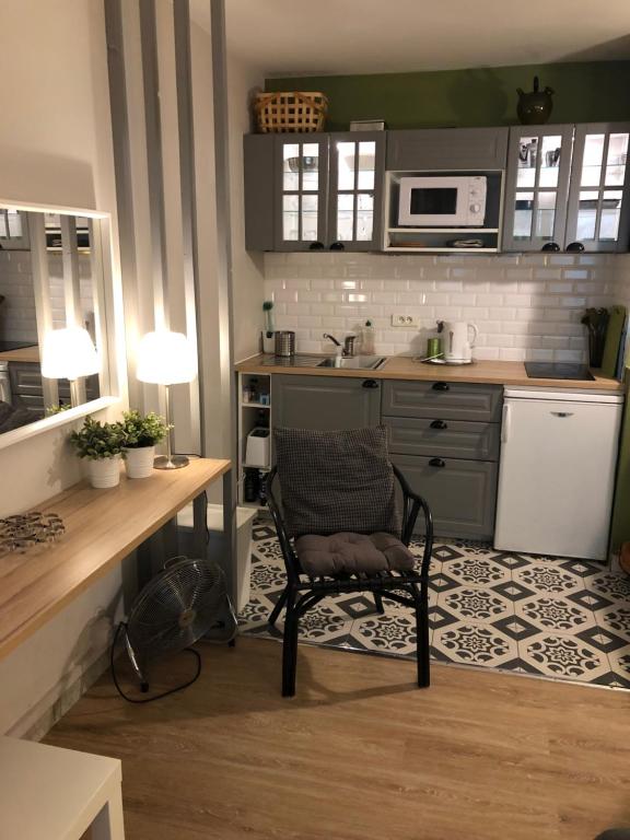 une cuisine avec une chaise en face d'un comptoir dans l'établissement Studio Clémenceau proche centre ville, à Montpellier