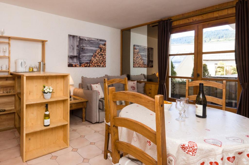a kitchen and living room with a table with wine bottles at Appartement Le Chamois in Megève