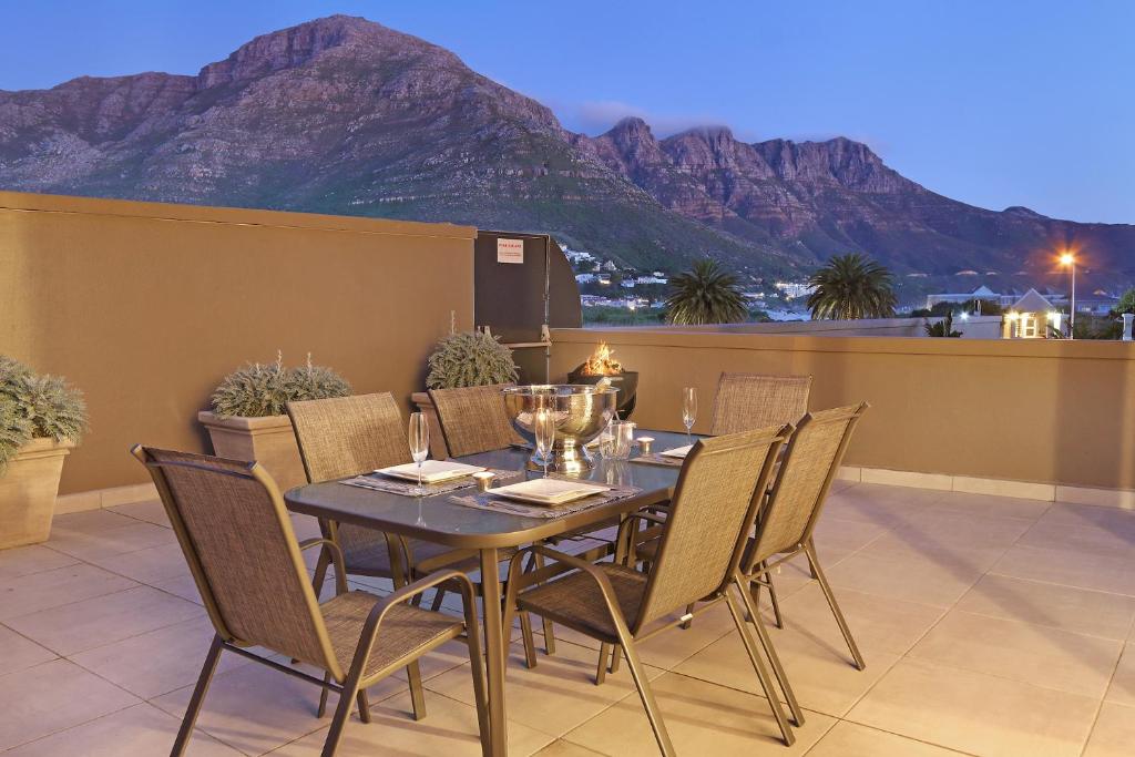 a dining table and chairs on a balcony with a mountain at G Zero 3 @ The Breakers in Hout Bay