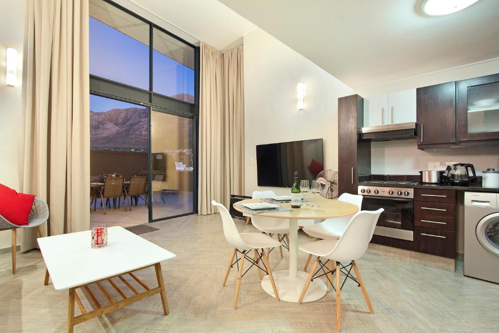 a kitchen and living room with a table and chairs at G Zero 3 @ The Breakers in Hout Bay