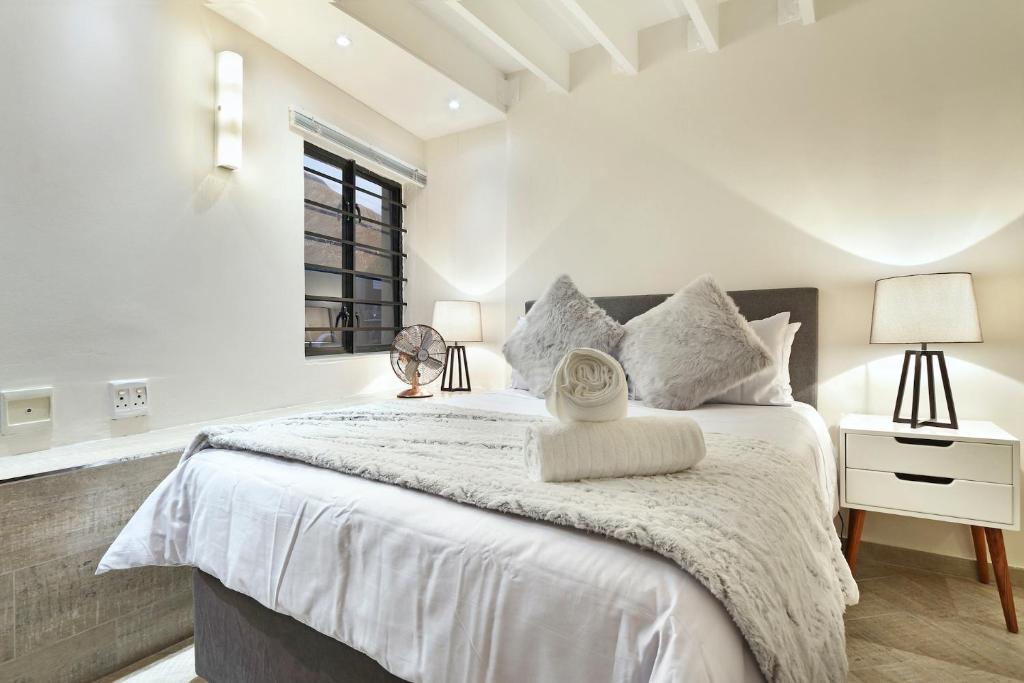 a bedroom with a large bed with white sheets at G Zero 3 @ The Breakers in Hout Bay
