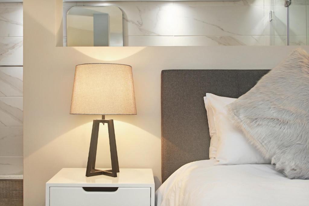a bedroom with a bed and a lamp on a night stand at G Zero 3 @ The Breakers in Hout Bay