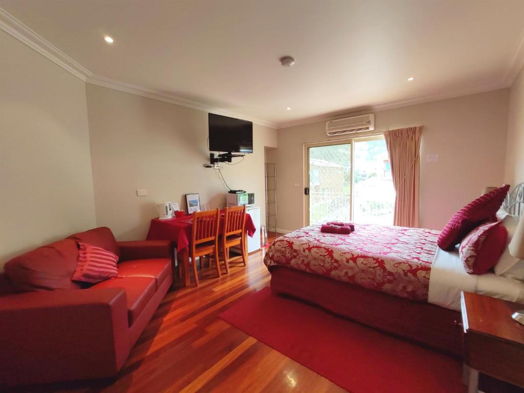 a living room filled with furniture and a red couch at Angela's Beach Stays in Apollo Bay