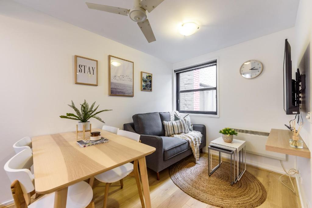 WOW Apartment on Flinders في ملبورن: غرفة معيشة مع طاولة وأريكة