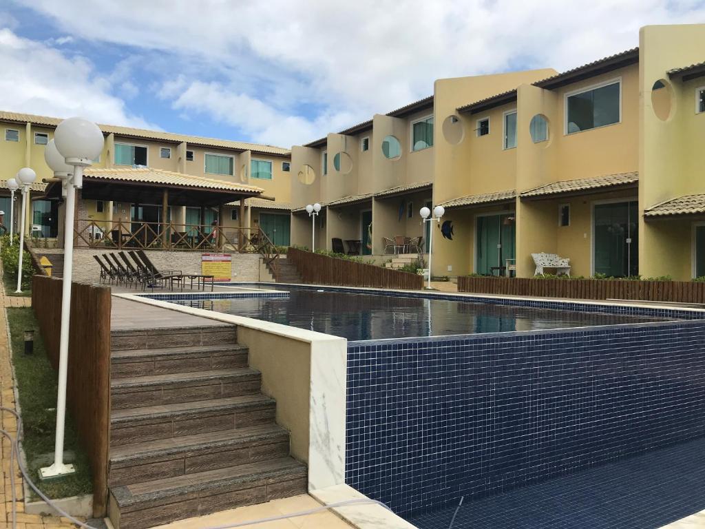 um edifício com uma piscina em frente em Imbassai Summer Flats Village em Imbassaí