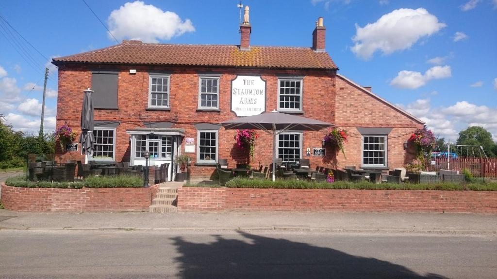 un edificio de ladrillo con un cartel delante en Staunton Arms, en Staunton in the Vale