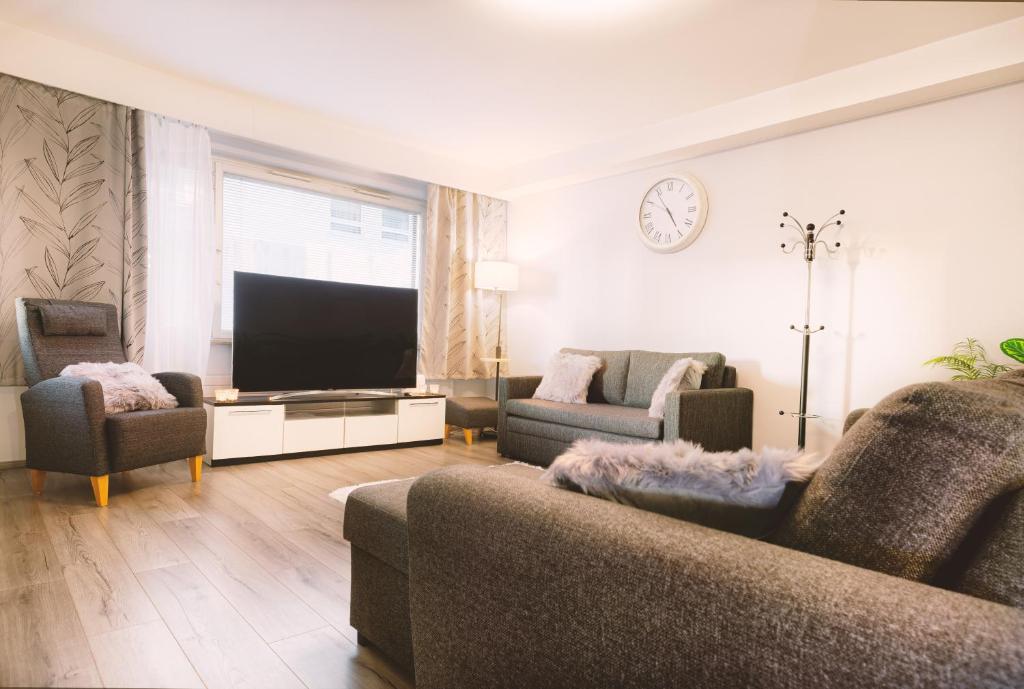 sala de estar con sofá y TV de pantalla plana en Apartment Rovakatu 27 B 10, en Rovaniemi