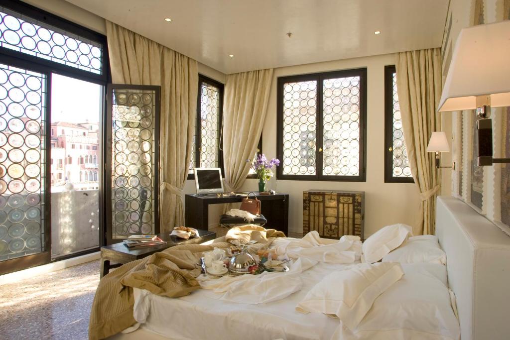 a large white bed in a room with windows at Ca' Nigra Lagoon Resort Adults Only in Venice