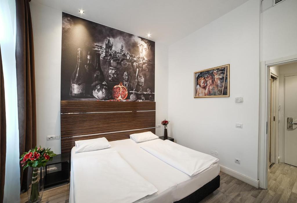 una camera da letto con un letto e un dipinto sul muro di Hotel Assenzio Prague a Praga
