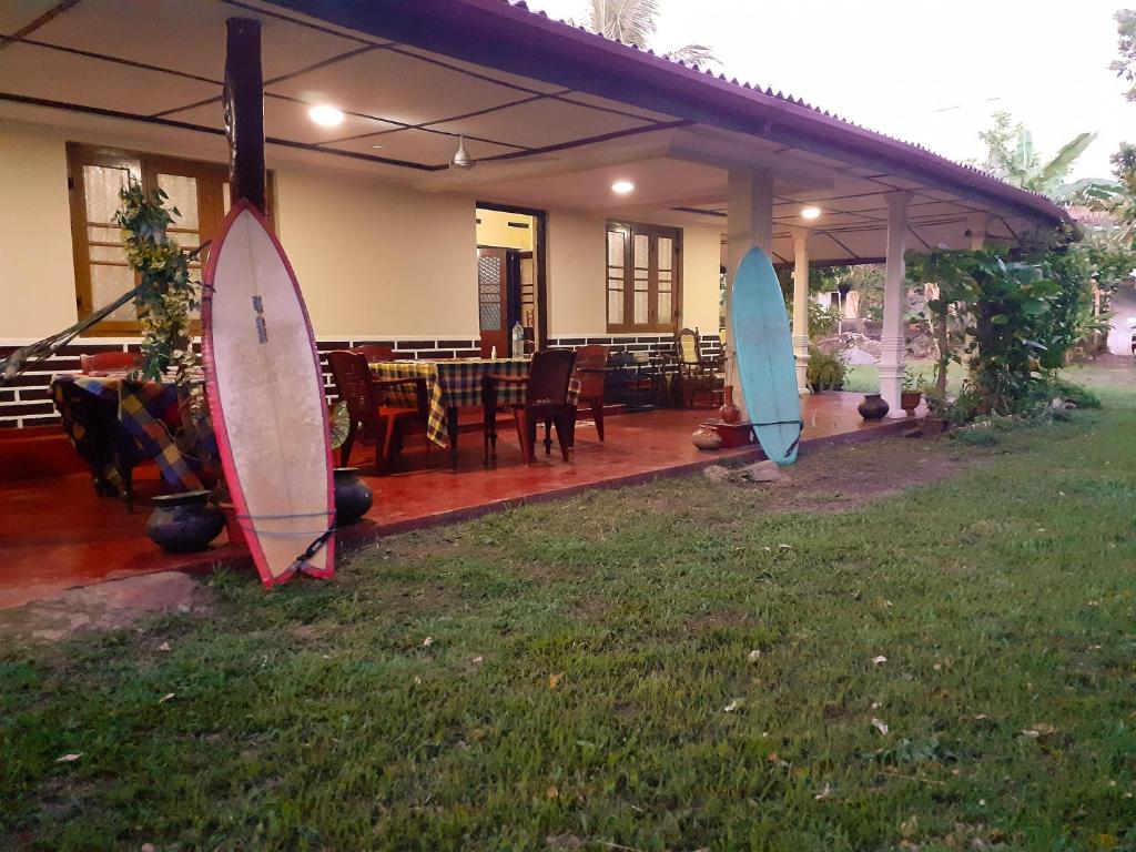 dos tablas de surf están de pie en el patio de una casa en Dreams Garden Surf Lodge, en Midigama East