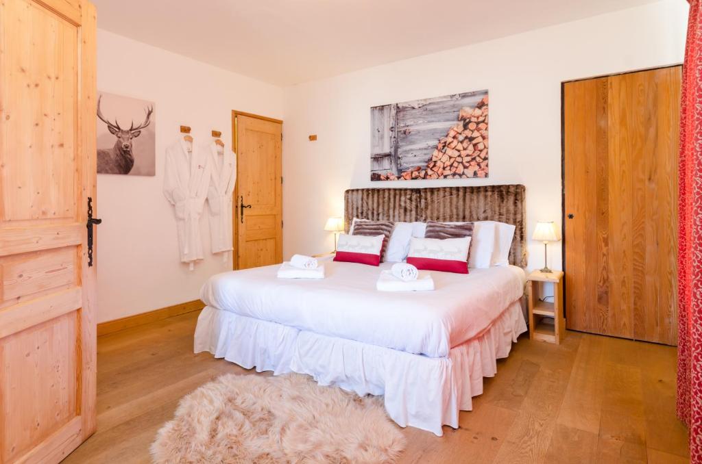 a bedroom with a large white bed in a room at Les Clochettes in Megève