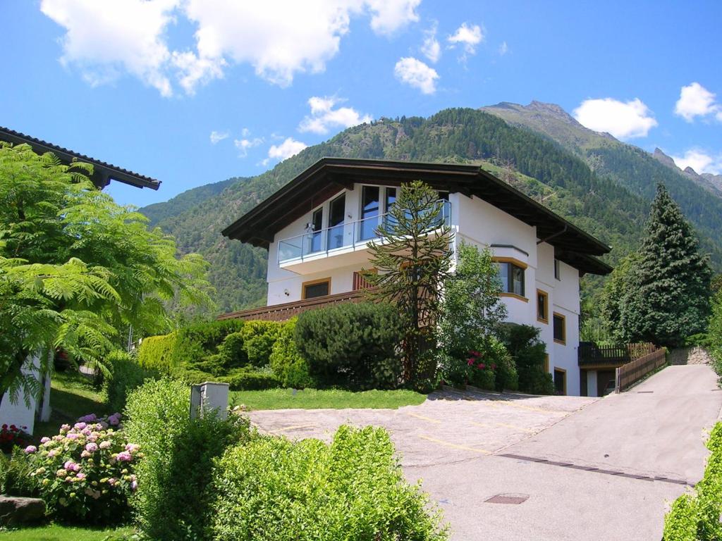 a large house with a mountain in the background at Appartements Oberpefohl in Parcines
