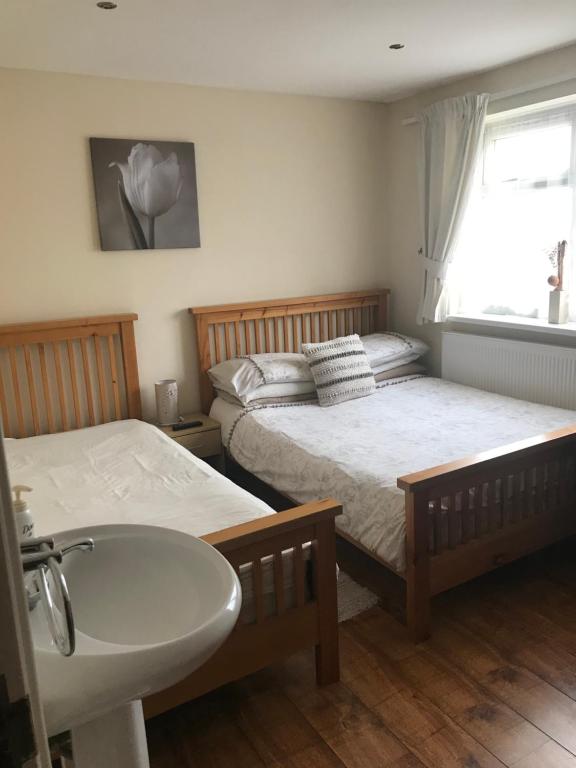 baño con 2 camas, lavamanos y lavamanos en Abbey Lodge Guest House, en Southampton