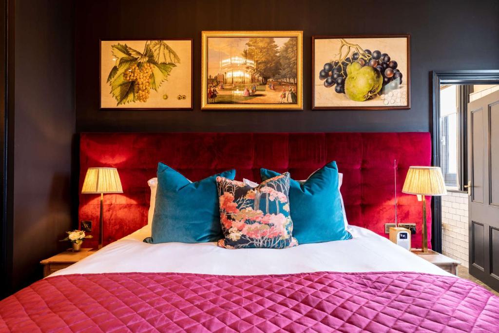 a bedroom with a large bed with a red head board at The Park Hotel in Teddington
