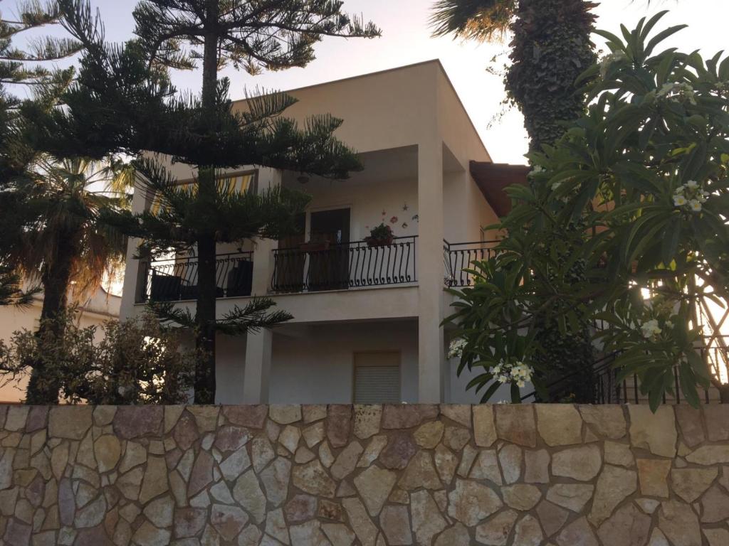 Casa blanca con árboles y pared de piedra en Villa Vella, en Sciacca