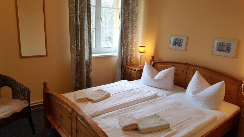 sypialnia z łóżkiem z białą pościelą i poduszkami w obiekcie Pension Am Holzgraben w mieście Lübbenau