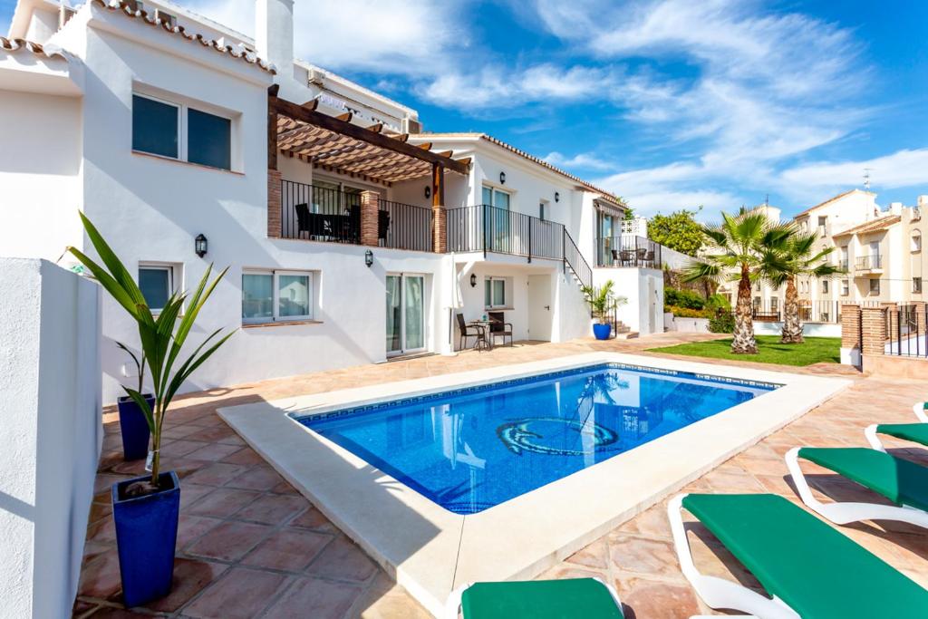 Villa con piscina frente a una casa en Villa Chispita & Sevilla Torreblanca en Fuengirola
