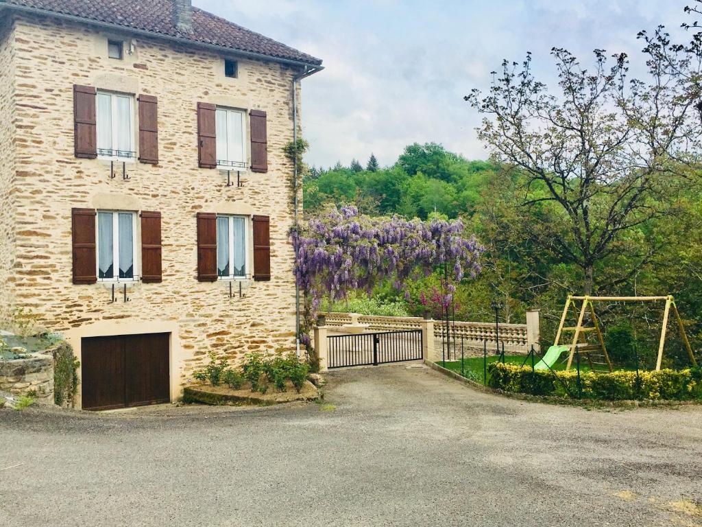 - un bâtiment avec une aire de jeux à côté d'une maison dans l'établissement Le renaissance, à Latouille-Lentillac