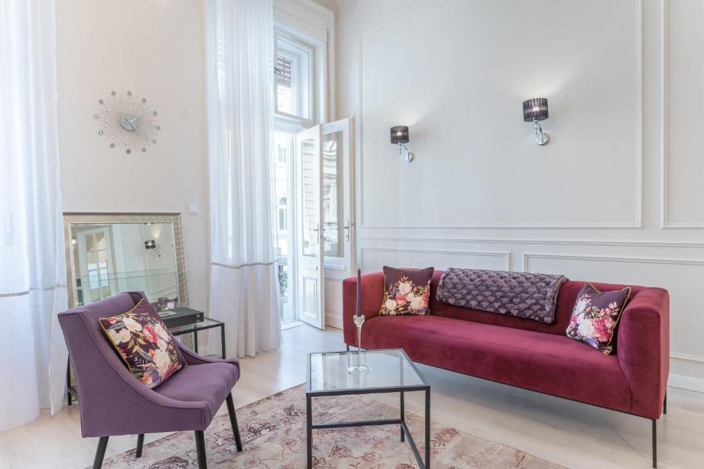 布達佩斯的住宿－Milano Design Apartment City Center，客厅配有红色的沙发和两把椅子