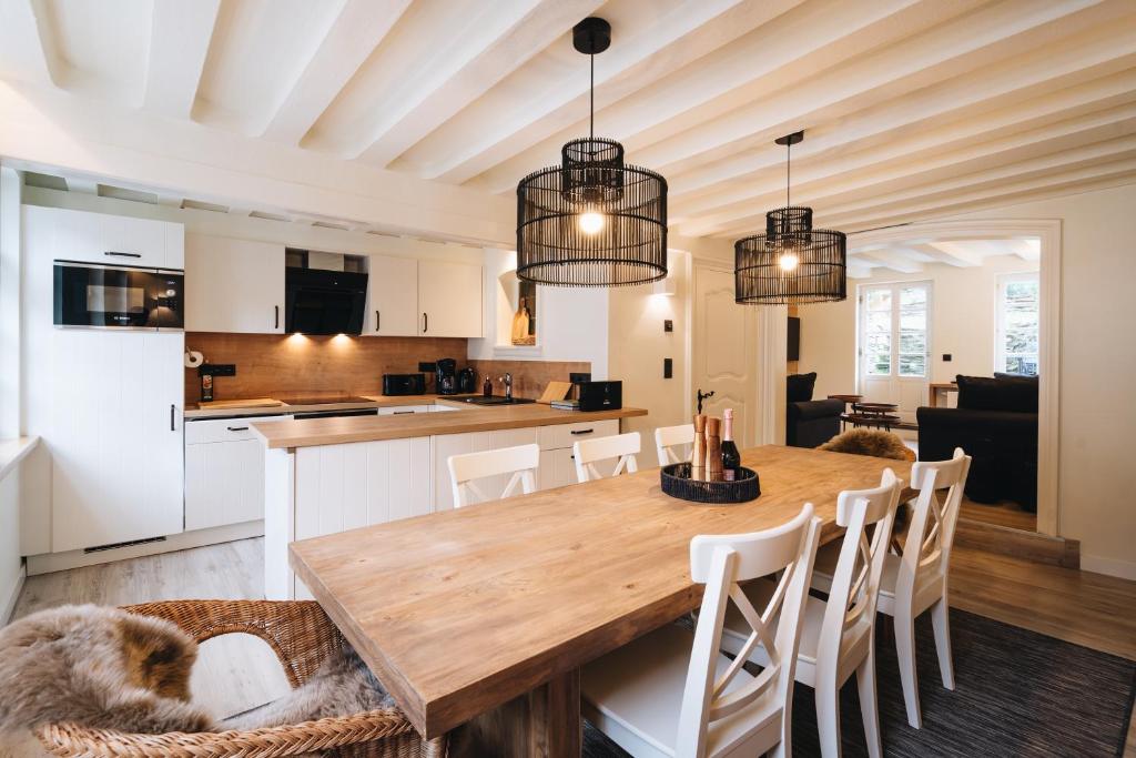 a kitchen and dining room with a wooden table and chairs at Holiday House BURGBLICK2 with garden - VOSPROPERTIES in Monschau