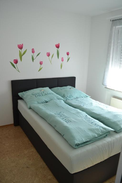 - une chambre avec un lit orné de fleurs roses sur le mur dans l'établissement Fewo I Schloßborn, à Glashütten