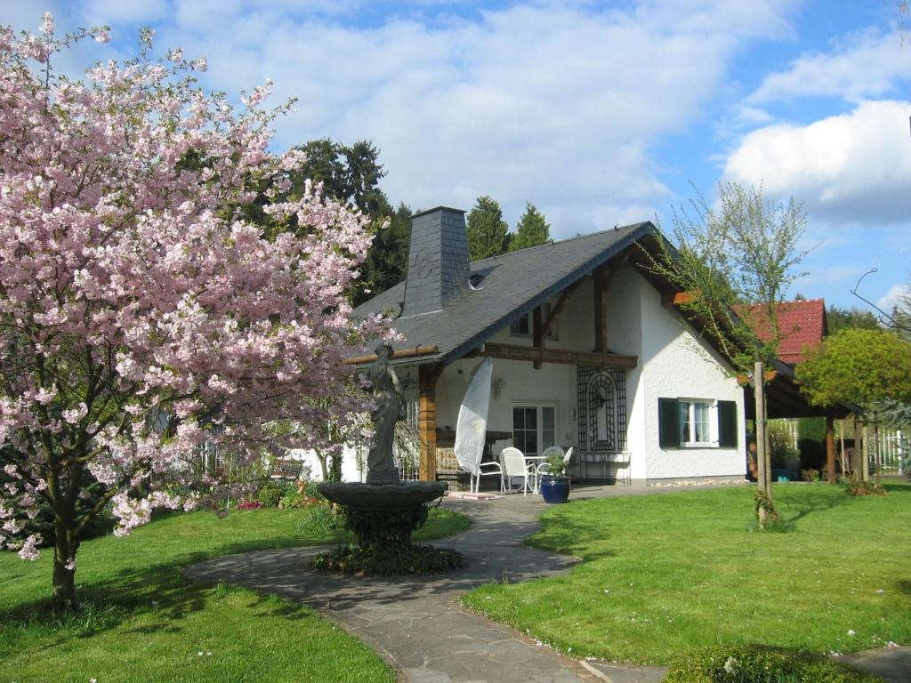 a house with a flowering tree in the yard at Schwallenberg 2 in Adenau
