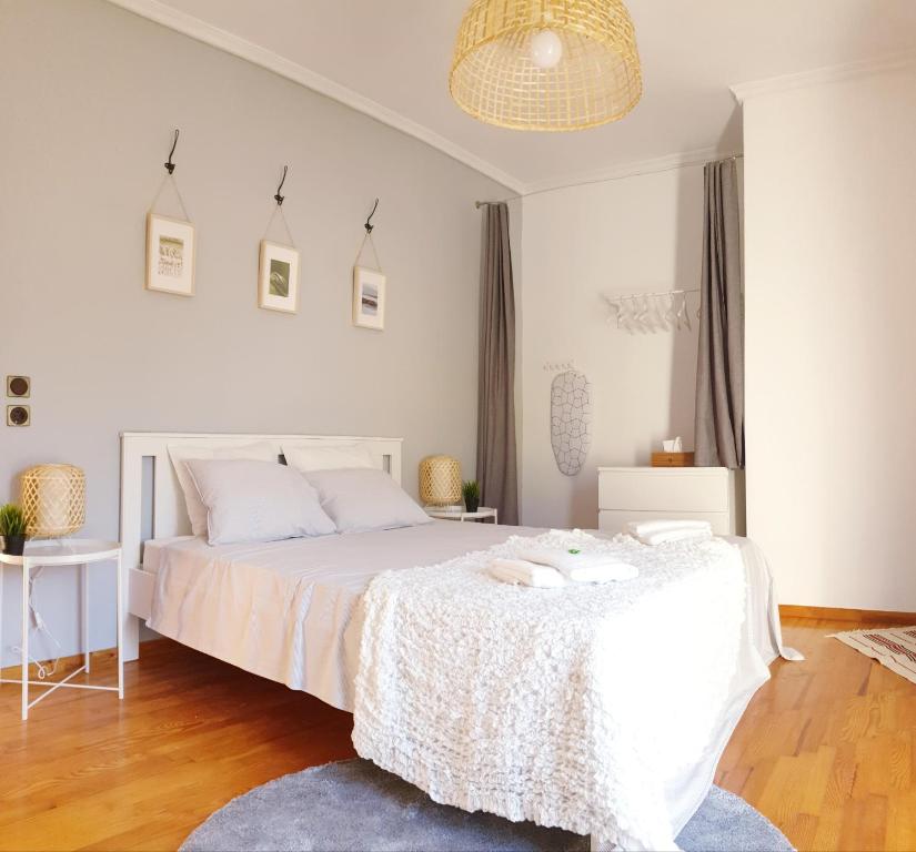 a bedroom with a large white bed and a chandelier at Cozy 100qm 3 Bedroom Apartment in Kerkíni