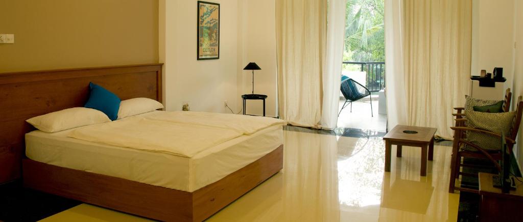 a bedroom with a bed and a large window at villa layanga - riverside guestrooms in Aluthgama