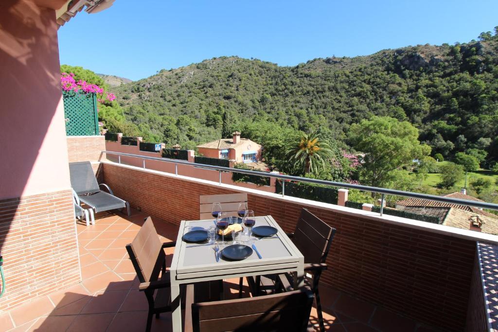 una mesa y sillas en un balcón con vistas en Benahavis Penthouse Apartment, en Benahavís