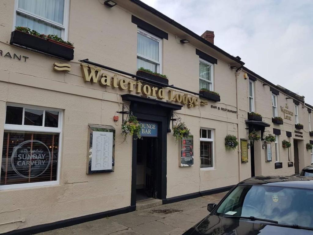 un coche aparcado frente a una tienda de practicantes en Waterford Lodge Hotel, en Morpeth