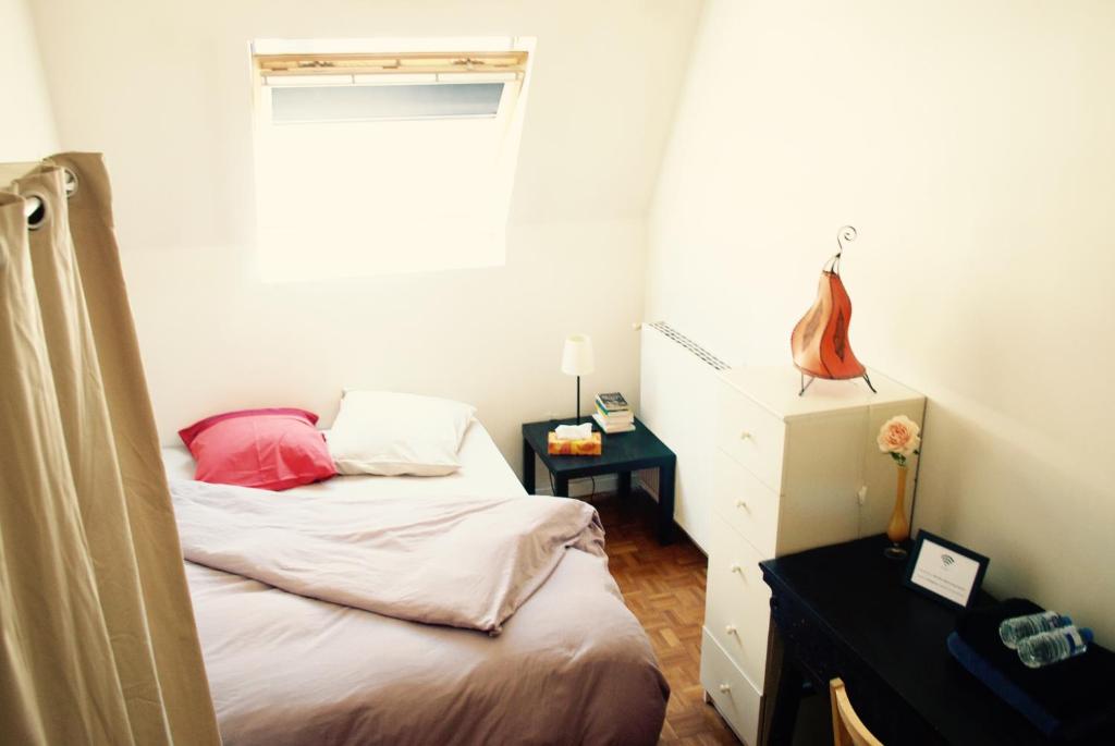 a small bedroom with a bed and a window at Chbre 2P + navette CDG in Aulnay-sous-Bois