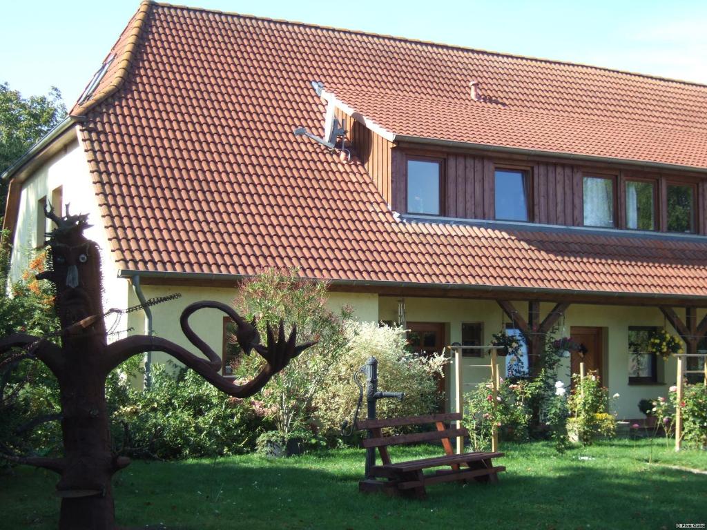une maison avec un banc devant elle dans l'établissement Five Oaks - Weisse Wohnung, à Hohenkirchen