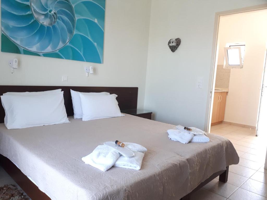 a bedroom with a bed with towels on it at Metaxa Apartments in Kavos