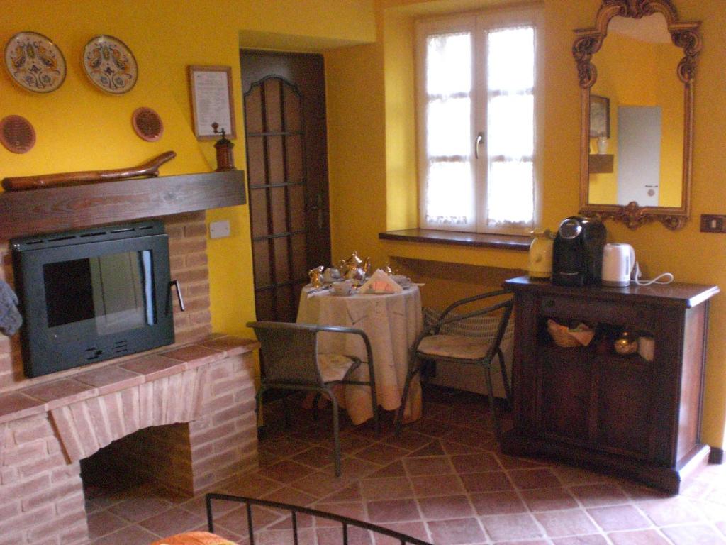 salon z kominkiem i telewizorem w obiekcie B&B NATURISTA Raggio di sole w mieście Cortazzone